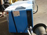 a man standing next to a blue machine in a parking lot