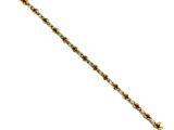 a close up of a gold bracelet with red stones on it