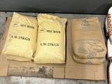 several bags of rice sitting on top of a cardboard box on a floor