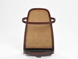 le dossier d'une chaise dont l'assise et les accoudoirs sont marron