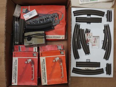 une boîte contenant des rails de train et d'autres accessoires de train