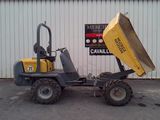 a small yellow dumper parked in front of a building