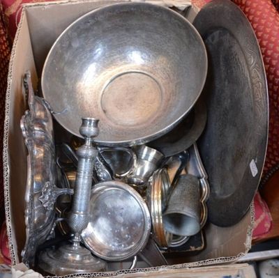 une boîte remplie d'objets en argent posée sur un canapé