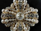 an image of a brooch with pearls and diamonds on a black background
