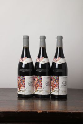 trois bouteilles de vin posées sur une table en bois