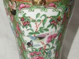 a vase with a bird on it sitting on a table