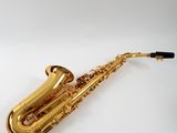 a close up of a gold saxophone on a white surface