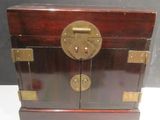 a small wooden box with a lock on top of it