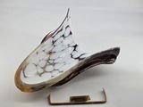 an image of a white and black glass sculpture with a gold pin