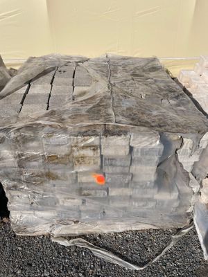un gros morceau de bois posé par terre à côté d'un tas de pierres