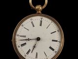 une montre de poche en or avec des chiffres romains sur le cadran