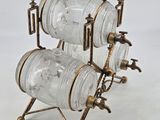 three glass jars are stacked on a stand on a white surface