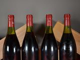 three bottles of red wine sit on a table next to a wooden box