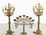 two large brass candelabs with candles on each of them