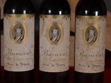 three bottles of red wine are lined up on a table