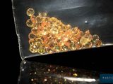 un sac transparent rempli d'une multitude de perles dorées