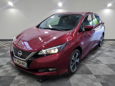 La Nissan Versa rouge est garée sur un sol à damier.