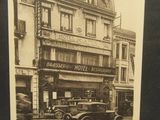 une vieille photo d'une vieille voiture garée devant un hôtel