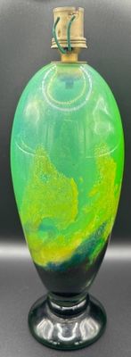 un vase vert et jaune posé sur une table noire
