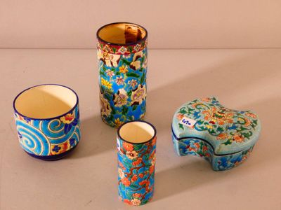 three vases and a cup sitting on a table