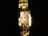 an image of a close up of a gold watch on a black background