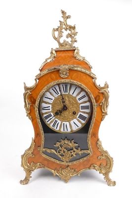 une horloge posée sur un support sur une surface blanche