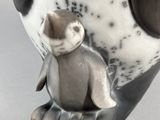 a close up of an owl figurine on a white surface