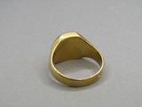 a close up of a gold ring on a gray surface