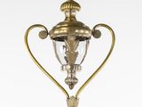 une lampe en laiton à l'ancienne, surmontée d'un abat-jour en verre