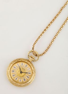a close up of a gold pocket watch on a chain