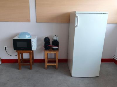 un réfrigérateur blanc et un micro-ondes dans une petite pièce
