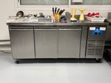 un plan de travail en inox sur lequel sont posés tout un tas d'ustensiles