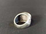 a close up of a silver ring on a black surface