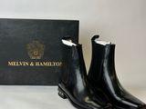 a pair of black leather ankle boots with a black box in the background