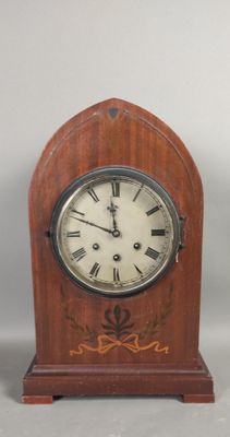 a small wooden clock with roman numerals on it