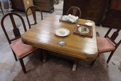 une table en bois avec quatre chaises et une assiette posée dessus