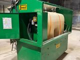 une machine verte dans un entrepôt, avec un tuyau à l'intérieur