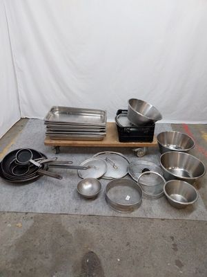 de nombreuses casseroles et poêles posées par terre