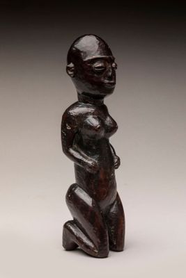 une petite statue en bois représentant un homme à la grosse tête