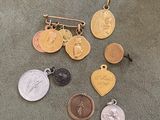 several gold and silver medals and a pin on a carpet