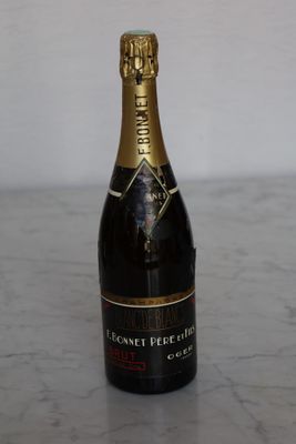 bottle of champagne sitting on a marble counter top with a white wall in the background
