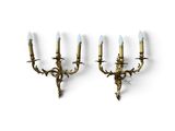 a pair of brass sconces mounted on a wall