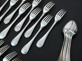 a lot of forks and spoons on a black table