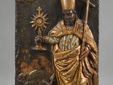 une image représentant une plaque en bronze sur laquelle figure un homme tenant une croix