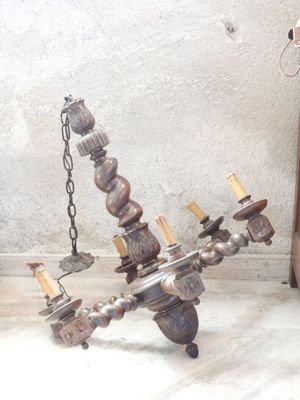 a metal chandelier that has a bunch of candles on it
