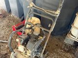 a lawn mower sitting on the ground next to a trash can