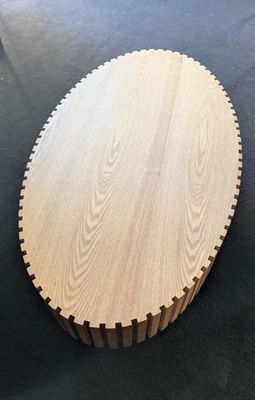 a round wooden cutting board sitting on top of a table