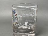 a glass with a design on it sitting on a table