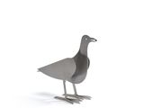 un oiseau en métal posé sur une surface blanche