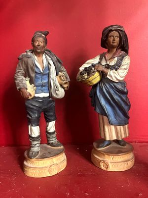 two figurines of a man and a woman standing next to each other